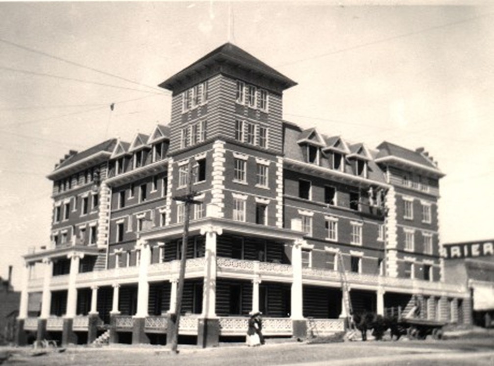 Black and white photo of large brick building with columns