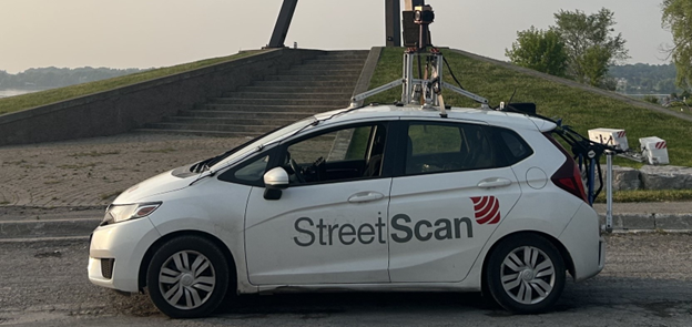 White vehicle with decal showing StreetScan and logo, large camera and other recording equipment attached