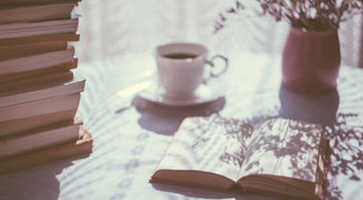 Stack of books beside cup of tea