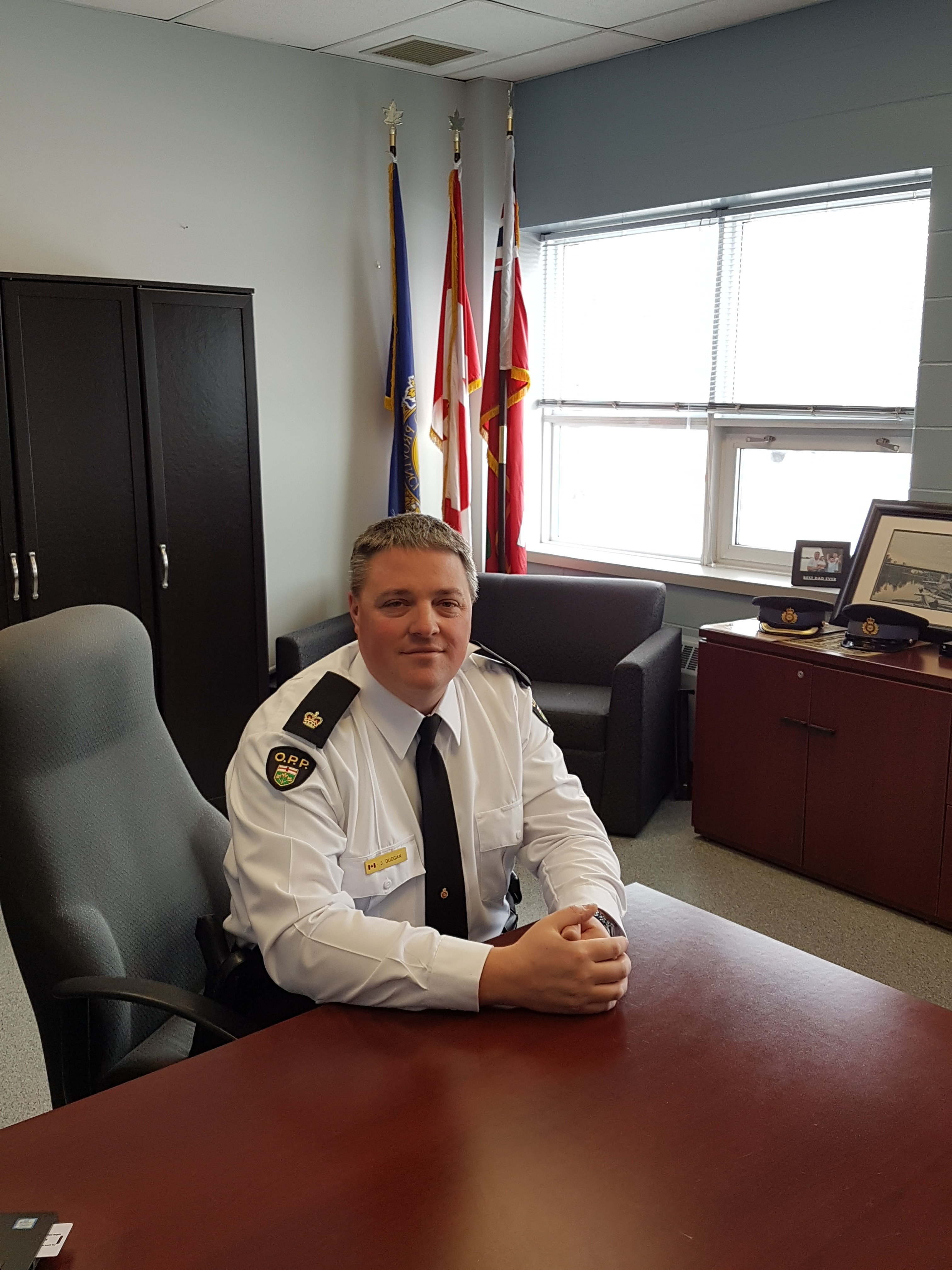 Man in police officer uniform, sitting at board room table