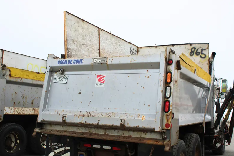 Close up view of the back of a plow truck with a decal that reads Goon Be Gone