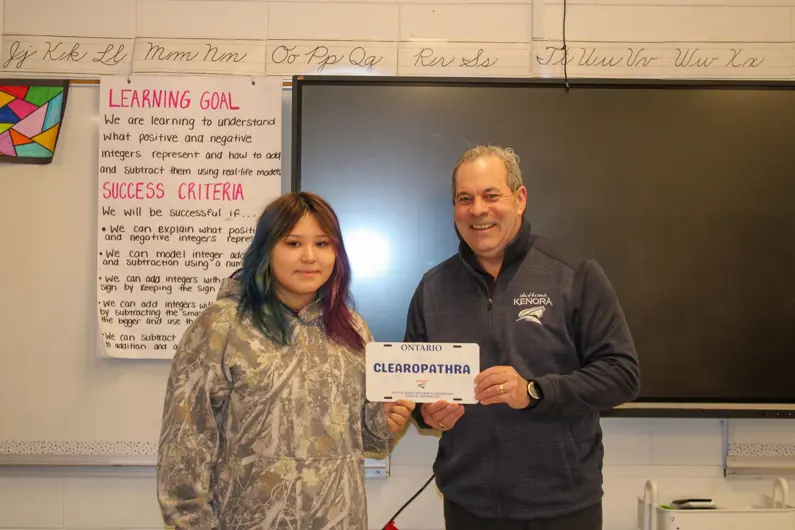 Mayor awarding student with contest keepsake