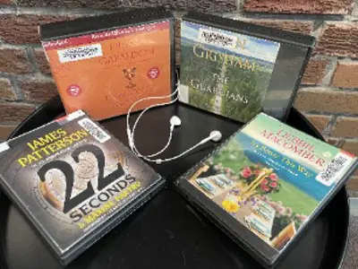 Four audio books displayed on a table.