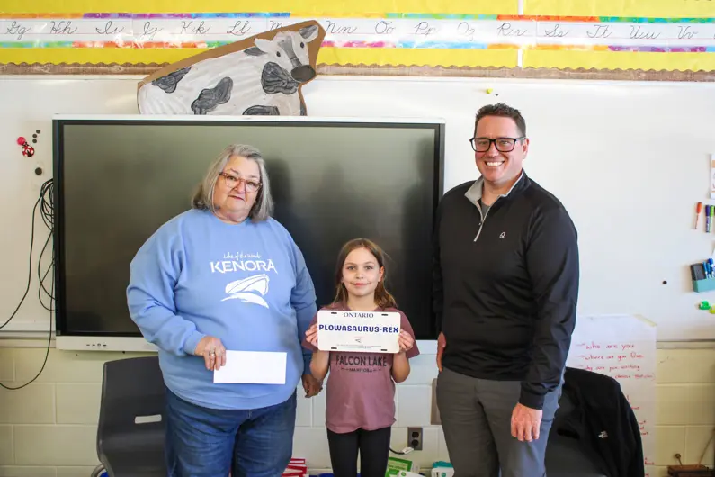 Two members of City Council awarding student with contest keepsake