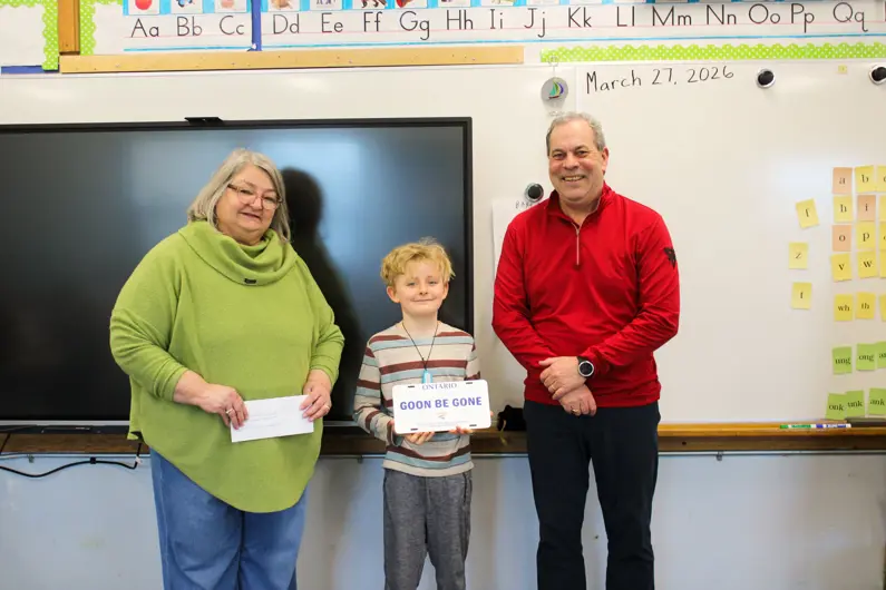 Two members of City Council awarding student with contest keepsake