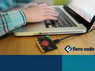 A child's arm is seen using a laptop with a microchip attached to it with the Fiero Code logo.