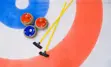 Curling rink with two brooms and three curling stones