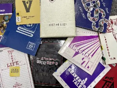 Yearbooks spread out on a table.
